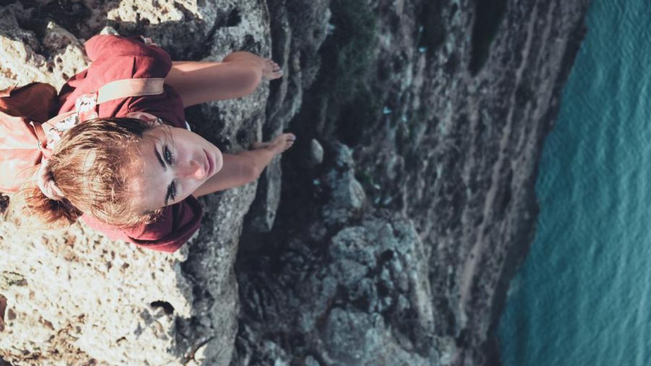 Girl Sitting On The Edge Of A Cliff Water