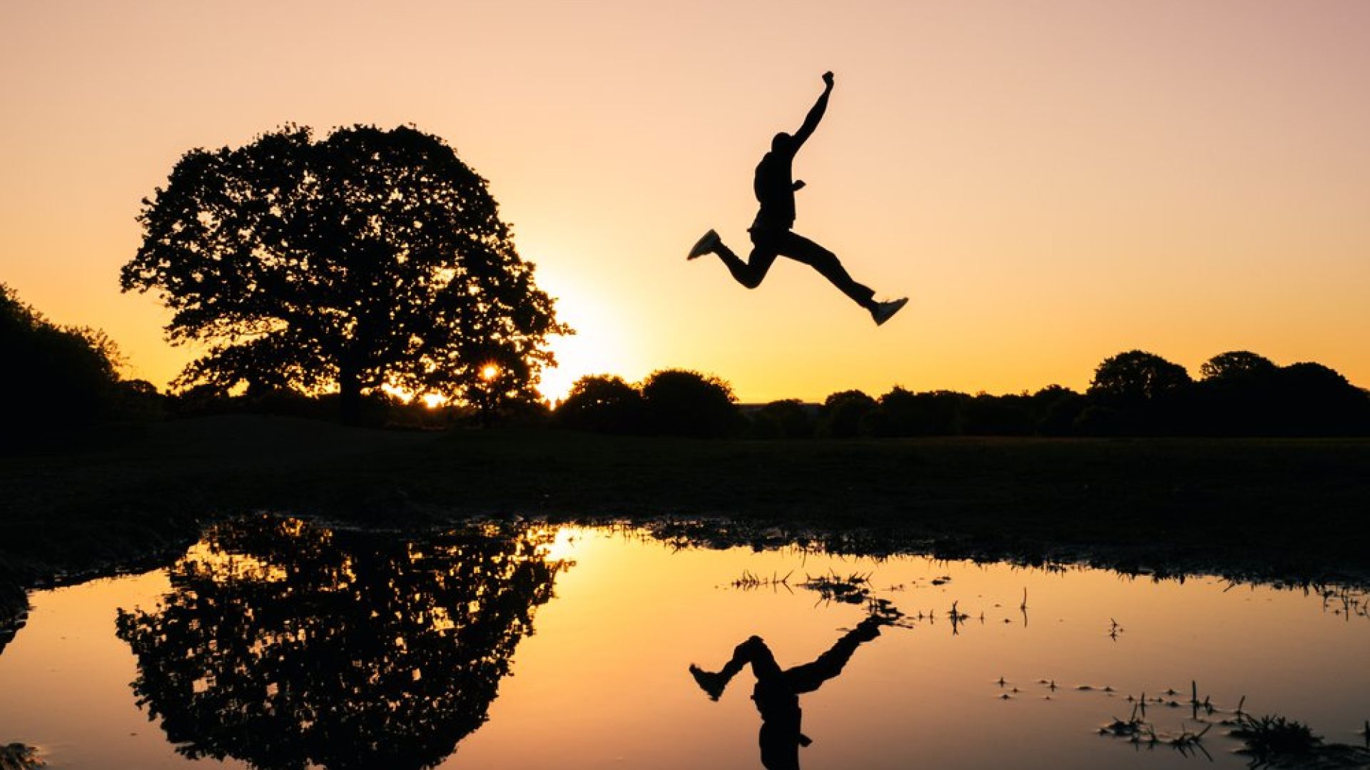 man jumping high across water