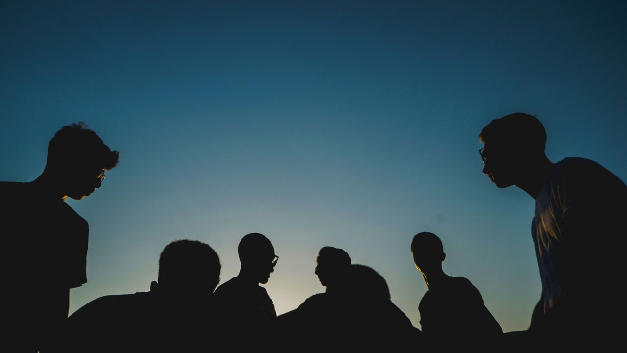 a group of men, outdoors at night