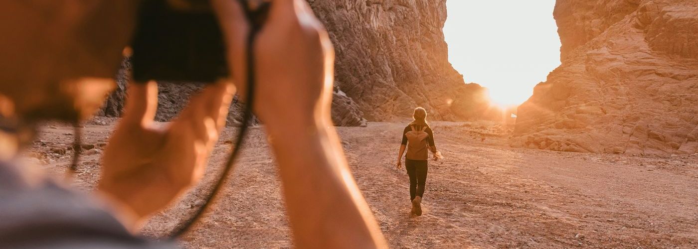 photographer taking a sunset photo with something walking out in the distance