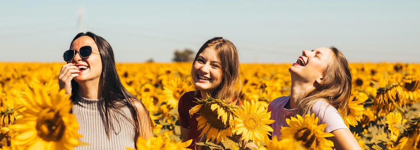 happy laughing women in a sunflower field