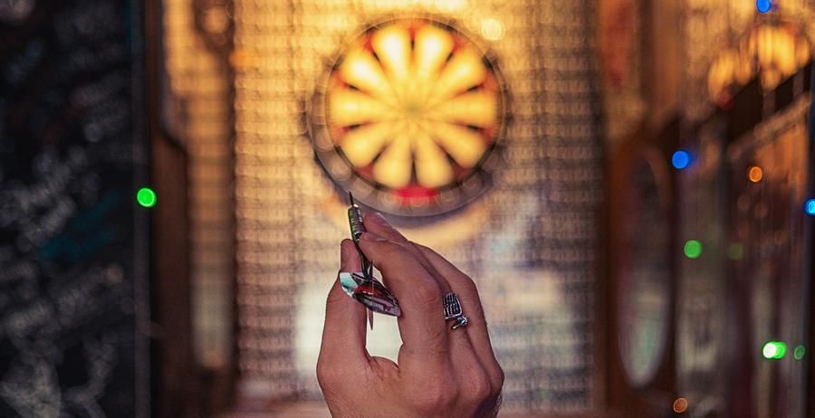 person preparing to throw a dart at the target