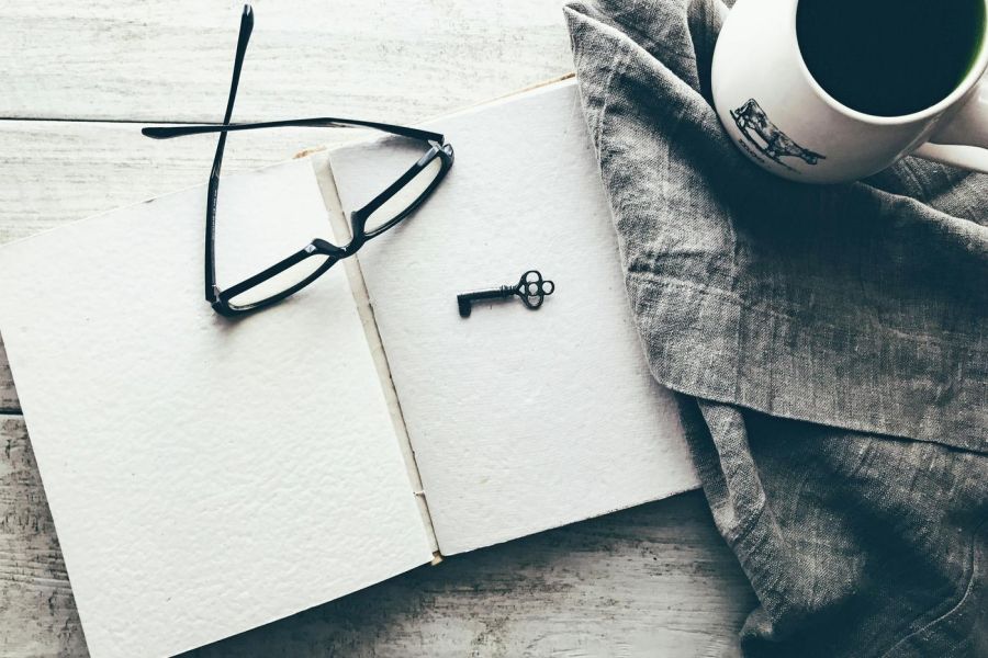 key and glasses on a note pad on a desk indoors