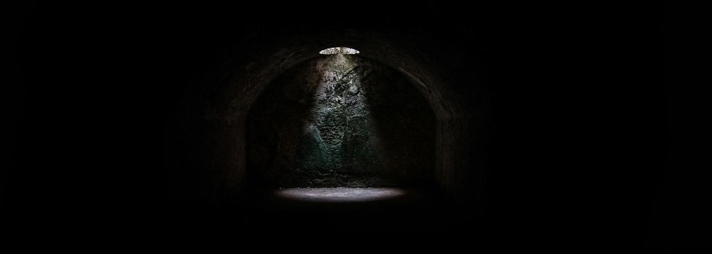 a dark dungeon with a light shining