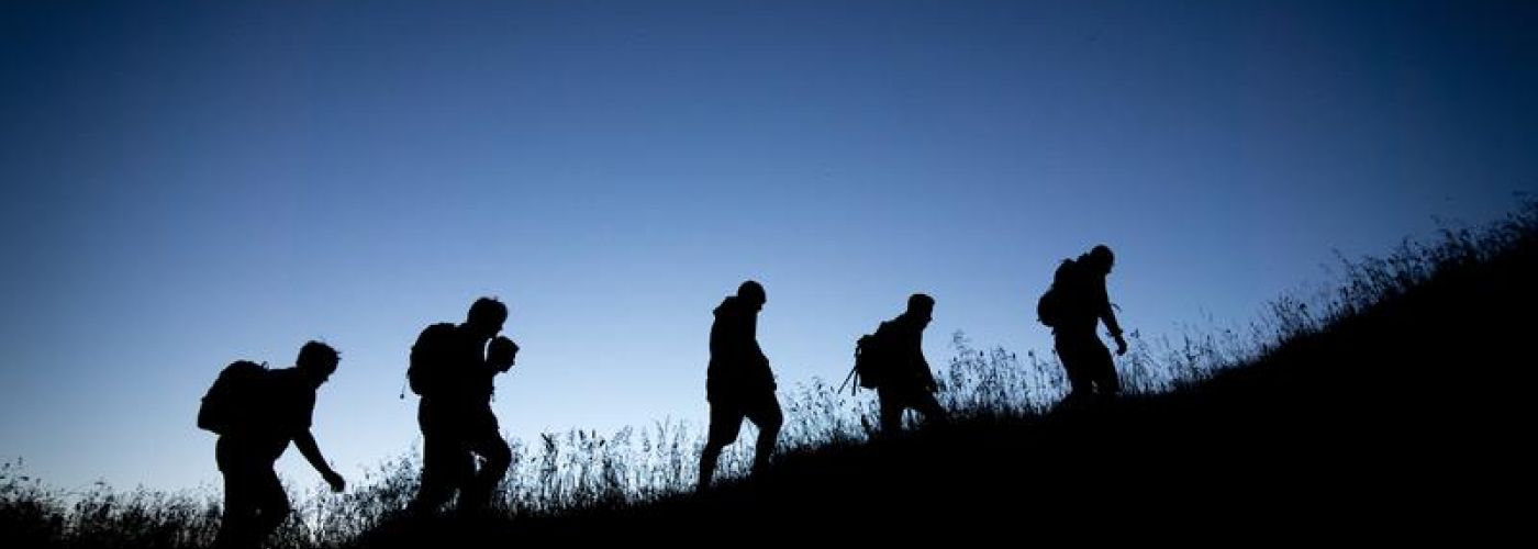 Group of people hiking up hill in the dark