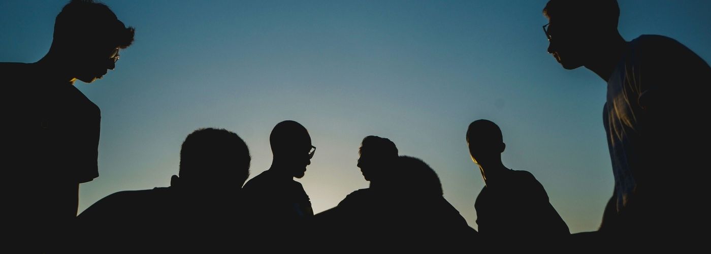 a group of men, outdoors at night