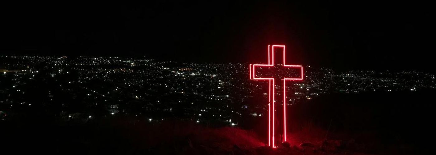 a cross in the city at night